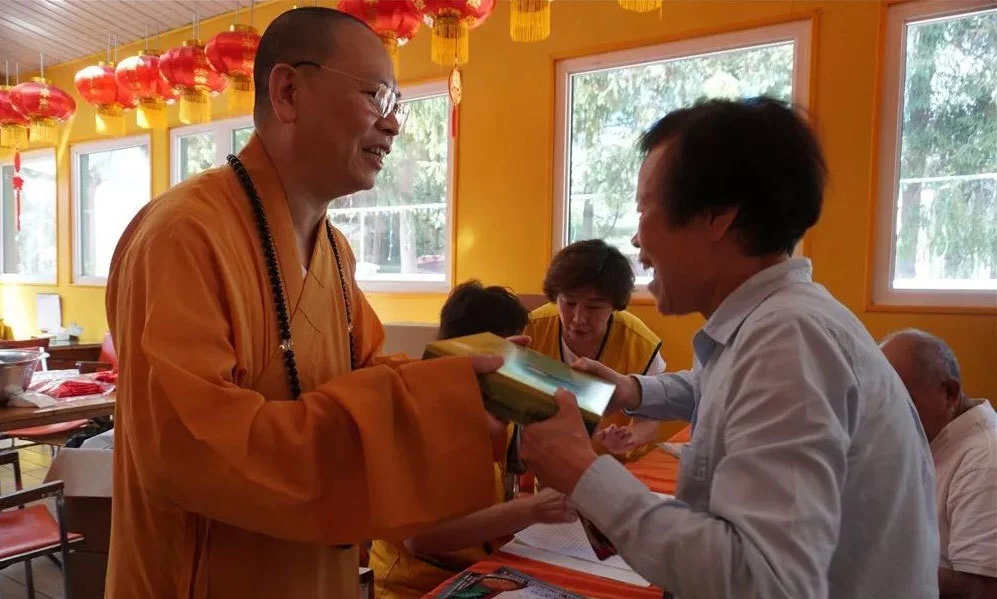 资料图：达义大和尚给耆老赠送湛山素月饼